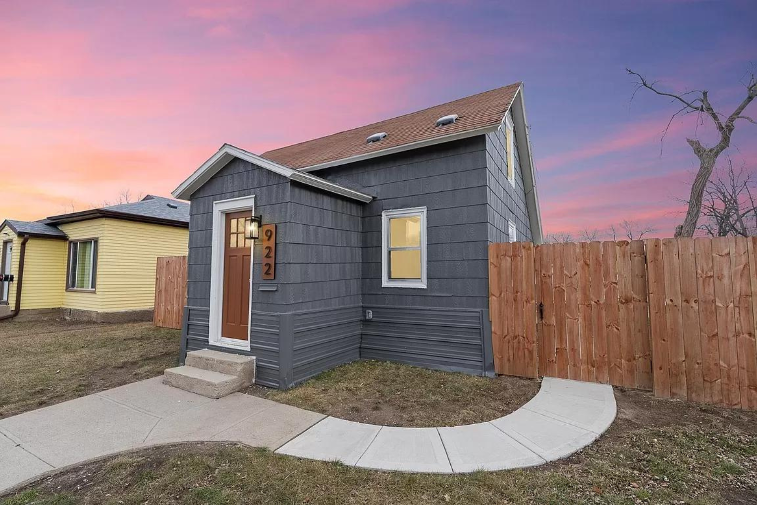 Two-story home with gray siding and fenced backyard at dusk in Sioux Falls, SD